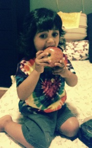 Riyaan takes a bite out of an apple.